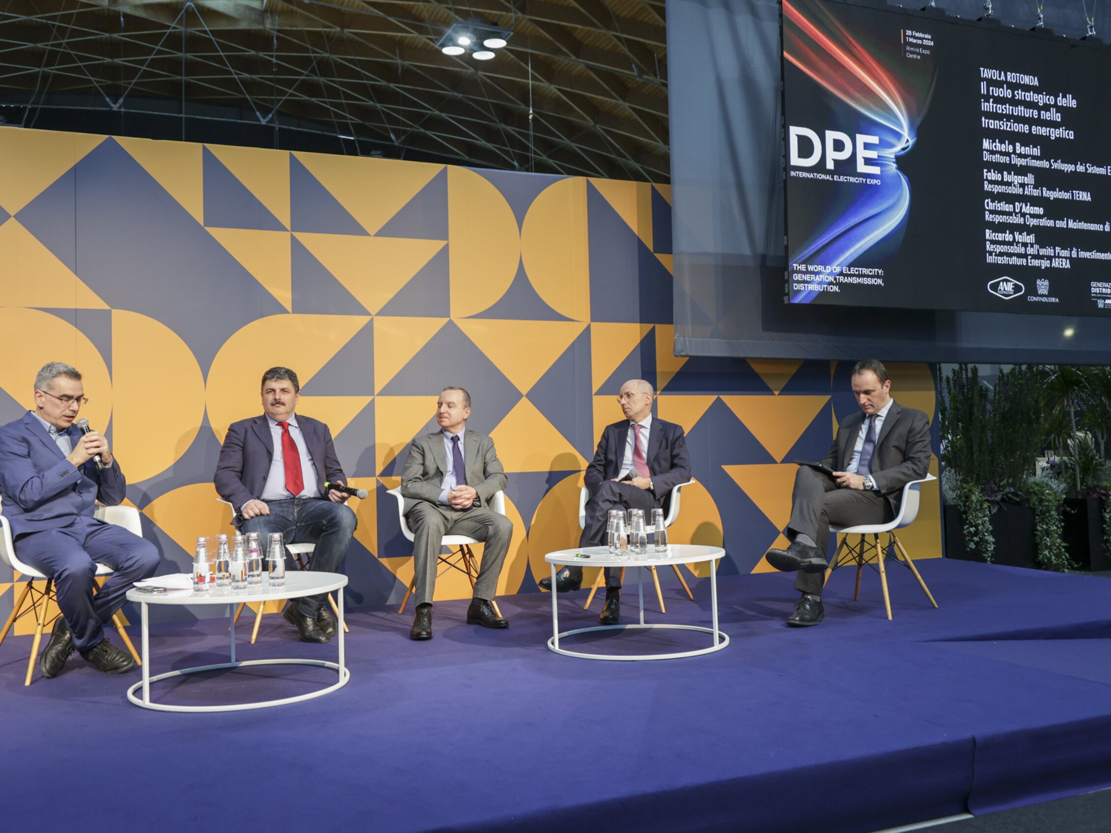 cinque relatori parlano sul palco durante una conferenza sul ruolo strategico delle infrastrutture nella transizione energetica