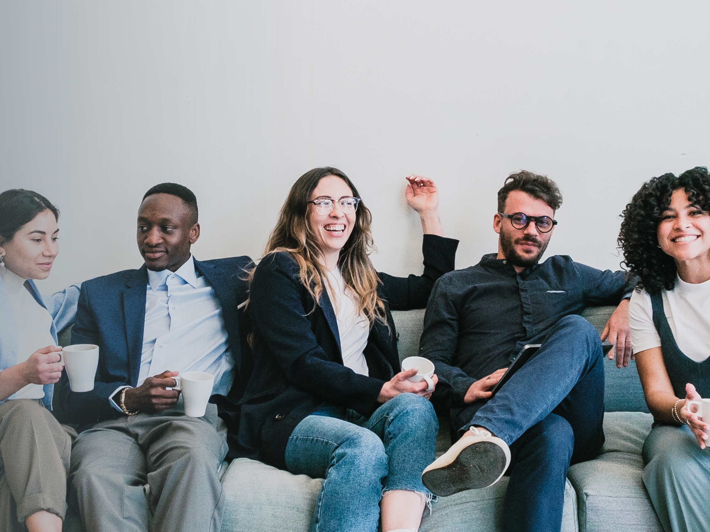 cinque studenti sorridenti seduti su un divano 